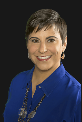 Dana Manciagli, professional headshot wearing business attire with confident expression against navy background